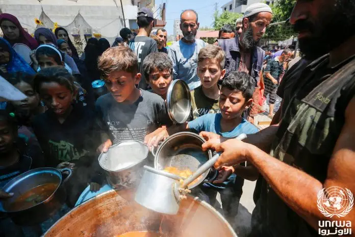 Displaced_Palestinians_gather_to_receive_food_from_a_charity_in_Deir_el-Balah,_Gaza_Strip_2